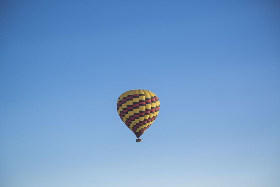 Free Image of Colorful hot air balloon floating against a clear blue sky 