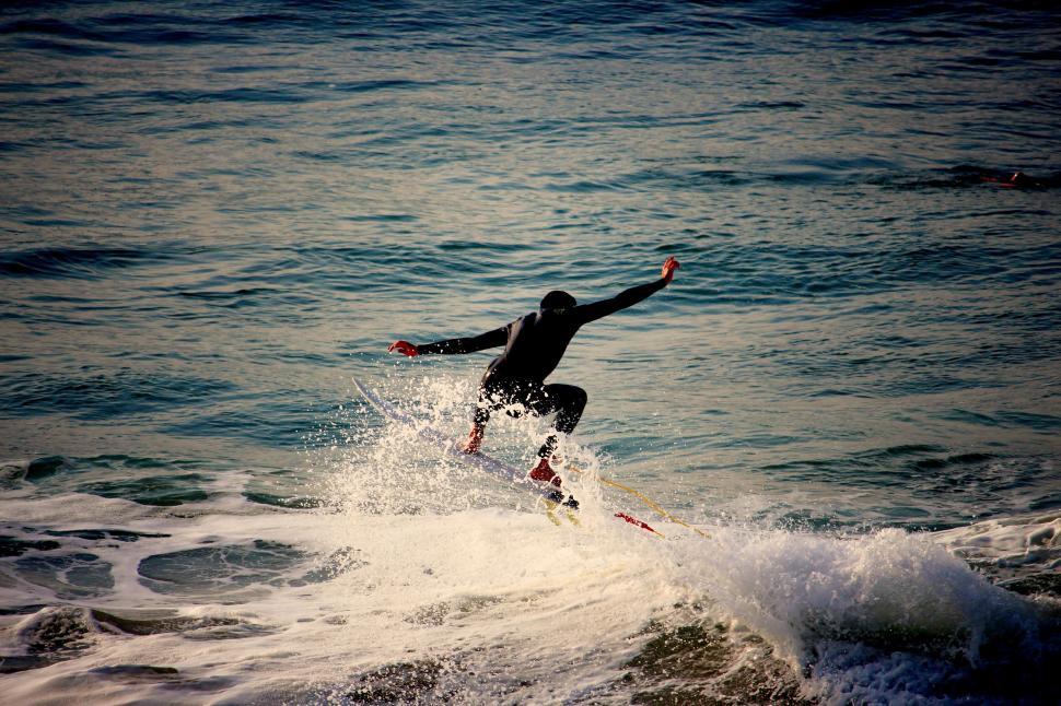 Free Image of Surfer skillfully riding a wave on an ocean with dramatic sprays 