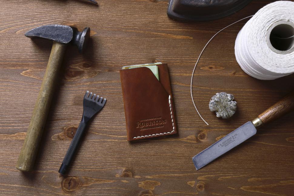 Free Image of Crafting tools laid out neatly on a wooden table with a wallet 