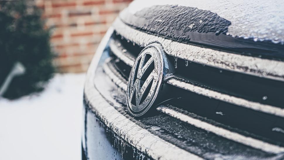 Free Image of Close-up of a Volkswagen car logo with frost and snow 