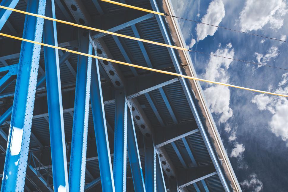 Free Image of Blue steel bridge structure against a sky with scattered clouds 