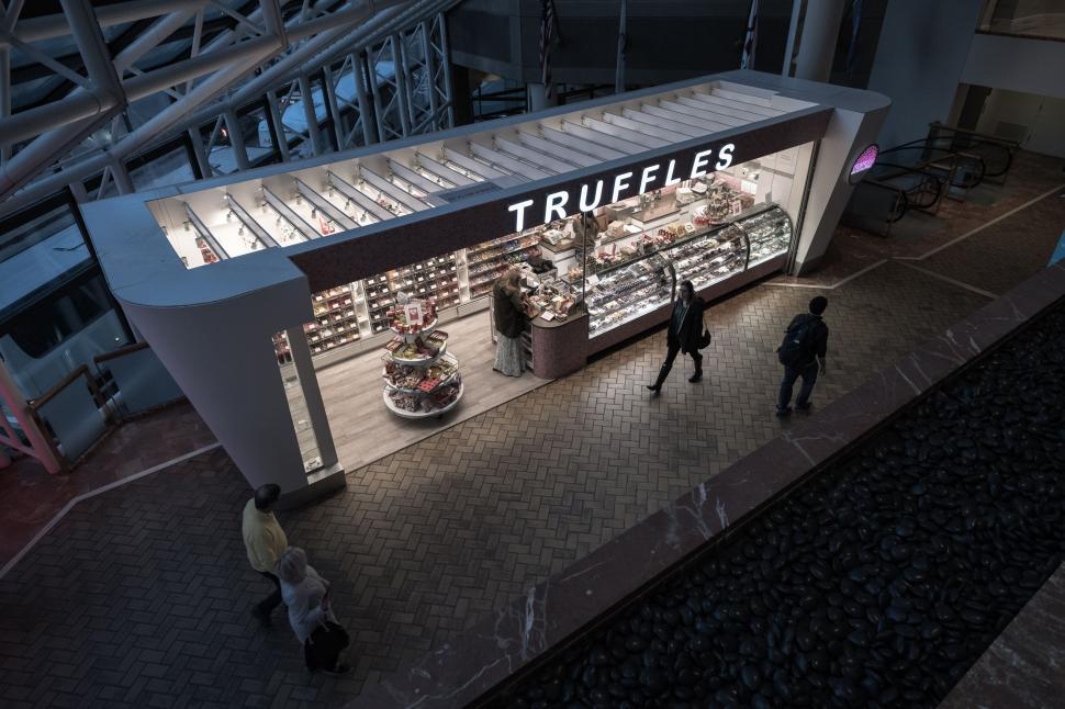 Free Image of Small truffles shop in a mall with people buying chocolate treats. 