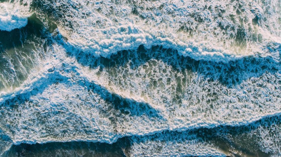 Free Image of Aerial view of ocean waves crashing creating majestic patterns 