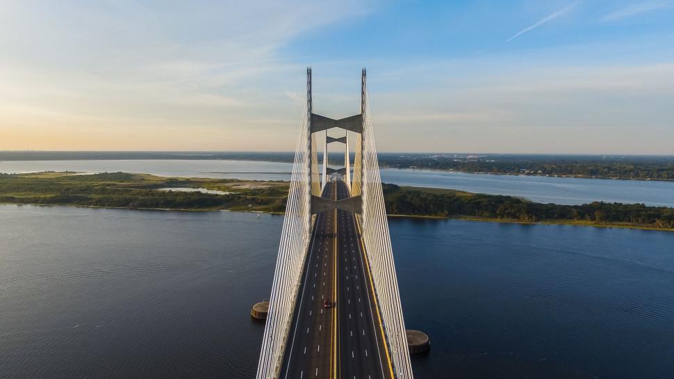 Free Image of Suspension bridge spanning water on sunny day with clear skies 
