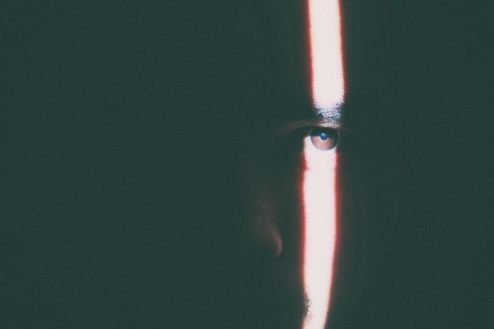 Free Image of Person s Face Partially Lit by a Narrow Beam of Light in Dark 