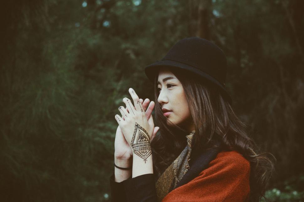 Free Image of Young woman with henna tattoo on hands in outdoor setting 