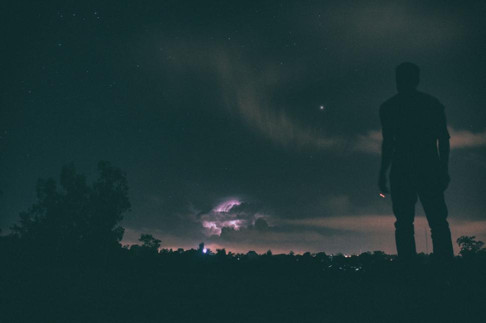 Free Image of Silhouette of person standing at night under star-filled sky. 