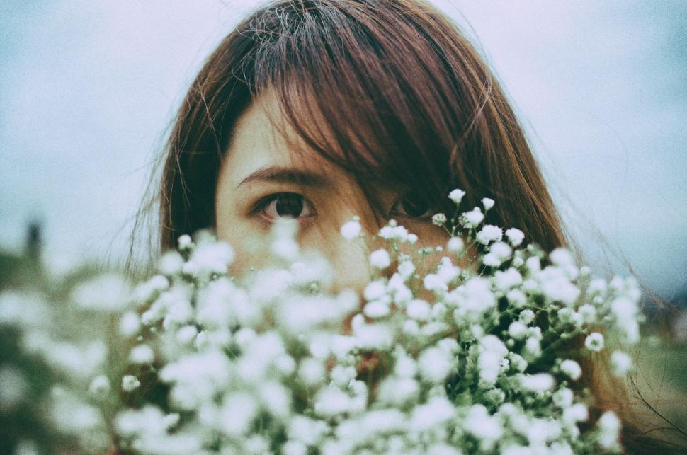 Free Image of Portrait with flowers framing the face in an outdoor setting 