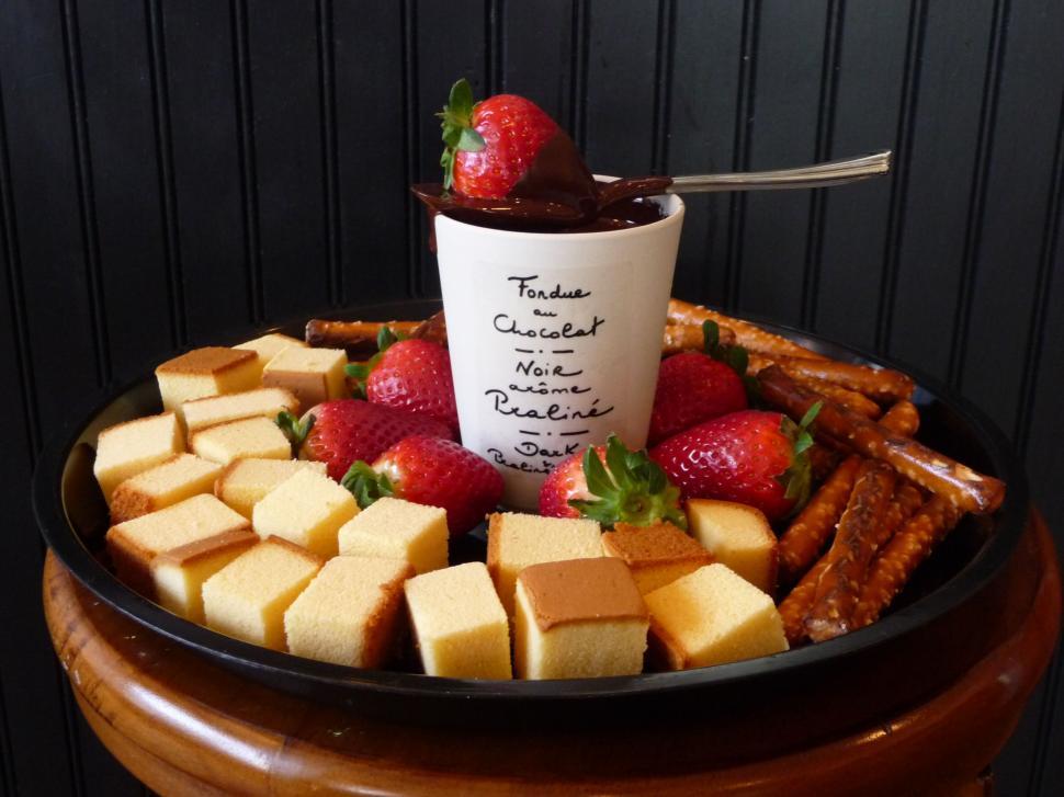 Free Image of Appetizing chocolate fondue with fruits, cake, and pretzels 