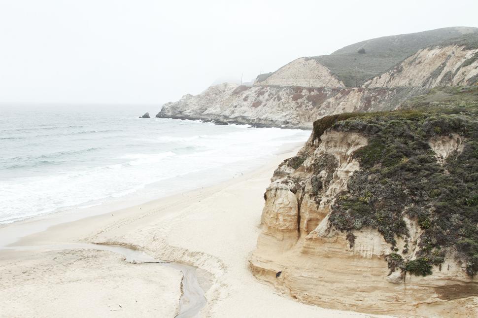 Free Image of Tranquil beach scene with waves gently lapping against the shore 