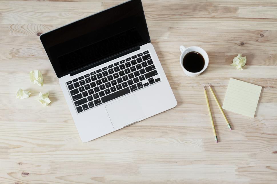 Free Image of Workspace setup with laptop, coffee, pencils, and sticky notes 