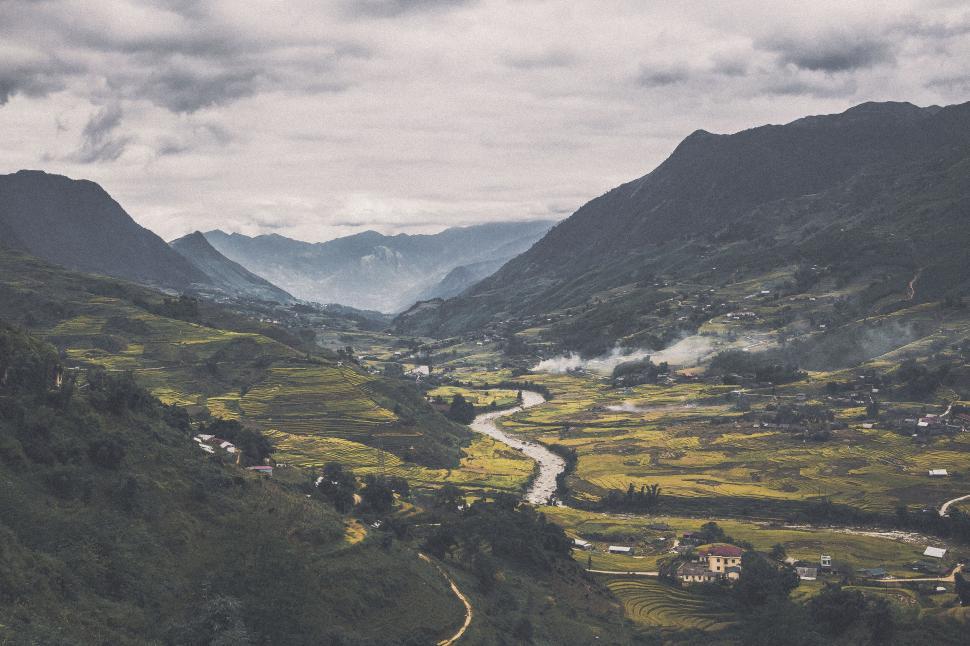 Free Image of Expansive view of terraced fields in a valley surrounded by hills. 