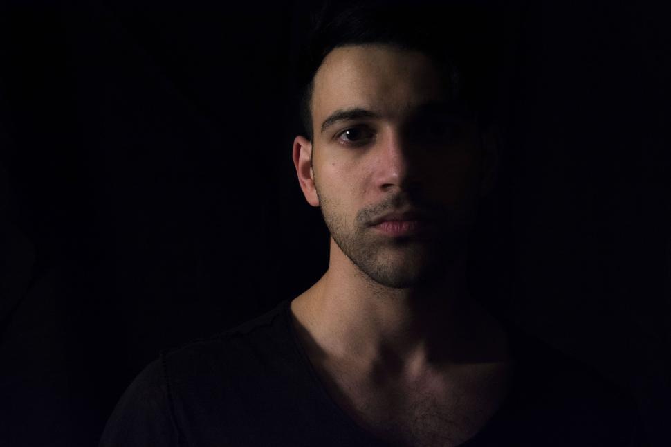 Free Image of Moody portrait of a man in dim lighting with serious expression 