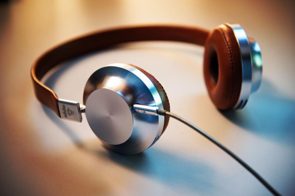 Free Image of Sleek modern headphones with brown leather elements on desk 