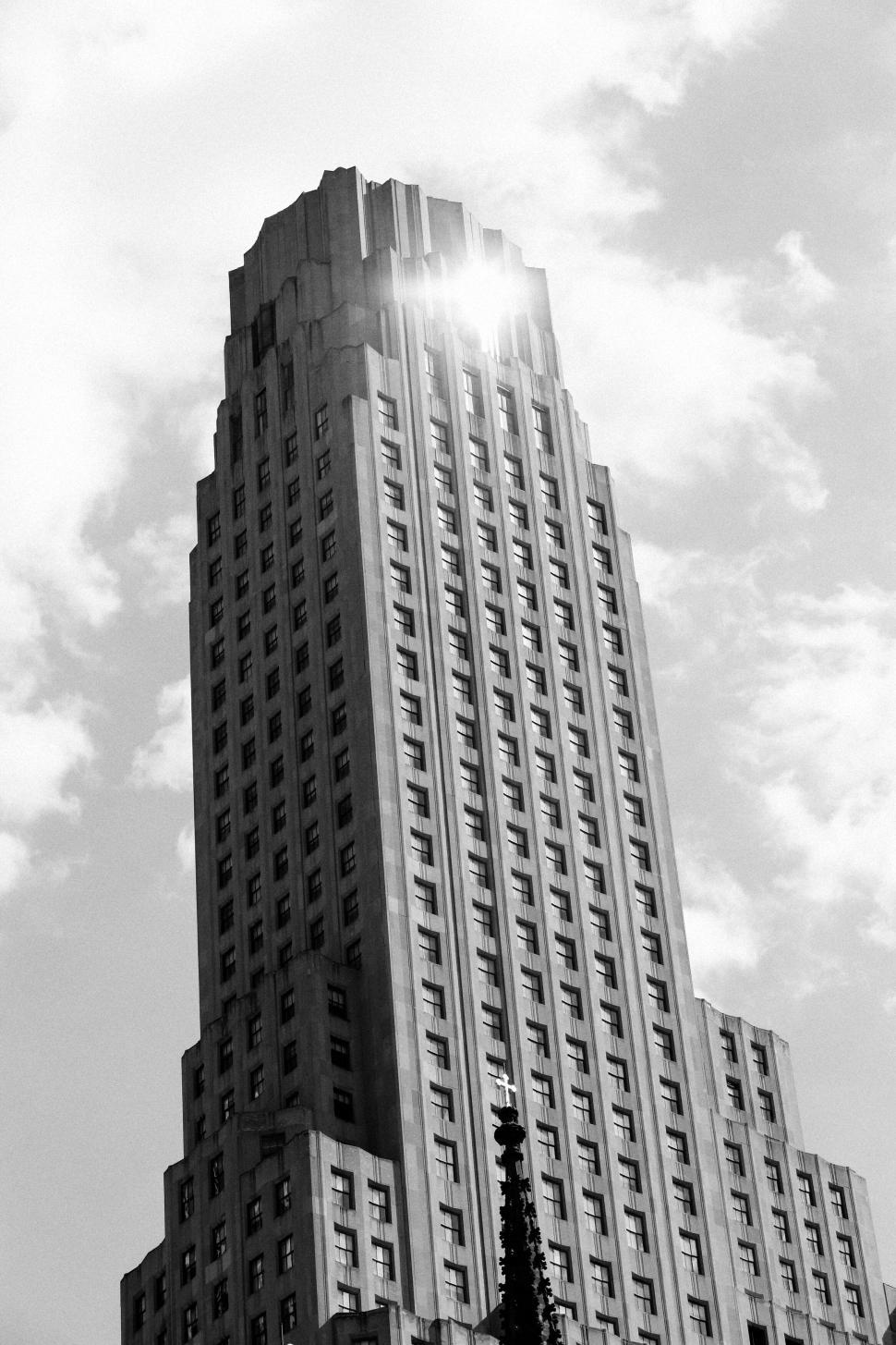 Free Image of Tall and majestic skyscraper with light reflecting off its top. 