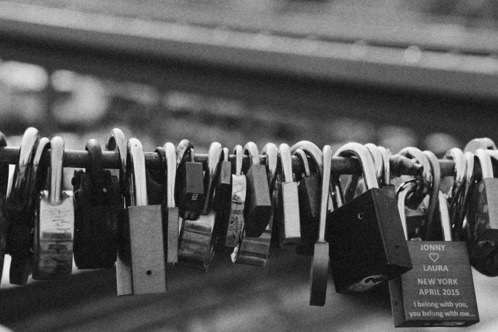 Free Image of Close-up of love locks on a bridge rail in monochrome photography. 