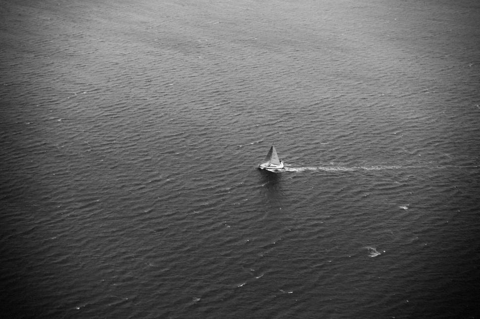 Free Image of Solitary sailboat traversing calm sea in a tranquil, peaceful setting. 
