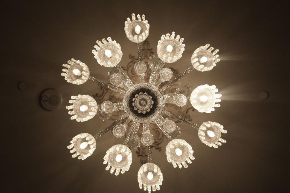 Free Image of Ornate chandelier with intricate design details and bright light bulbs. 