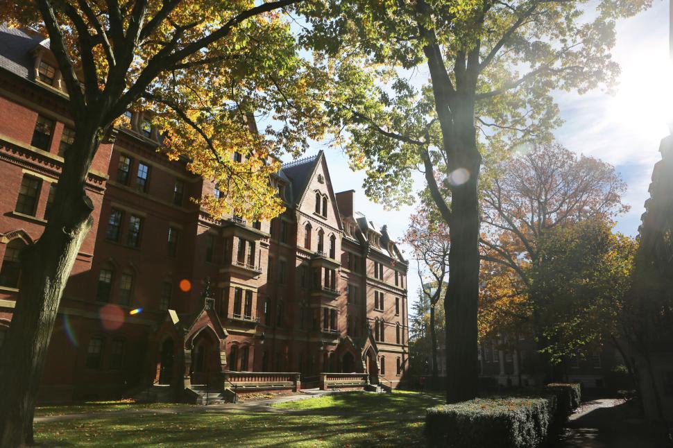 Free Image of Historic brick building on a sunny autumn day with leafy trees 