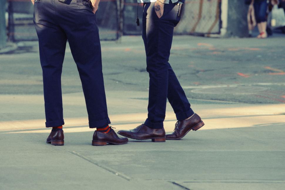Free Image of Two people in stylish shoes having a street-side conversation 
