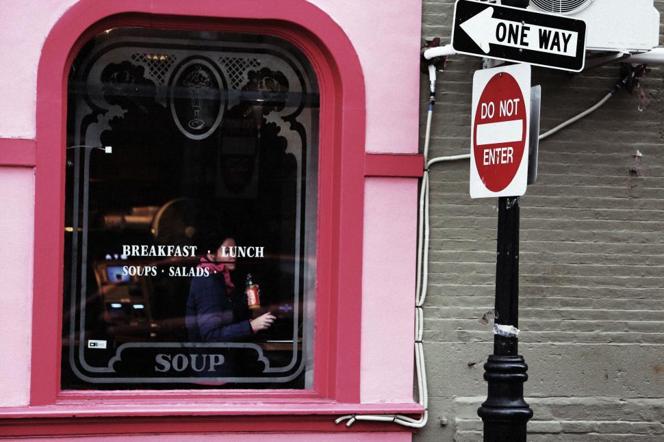 Free Image of Pink storefront with window and signage in urban city setting 