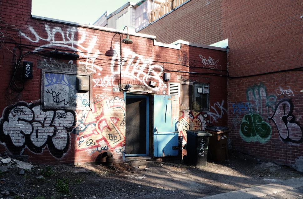 Free Image of Colorful graffiti artwork on brick walls in a narrow urban alley. 