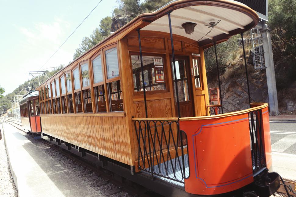 Free Image of Vintage wooden tram carriage on a rail track in a scenic mountain route 