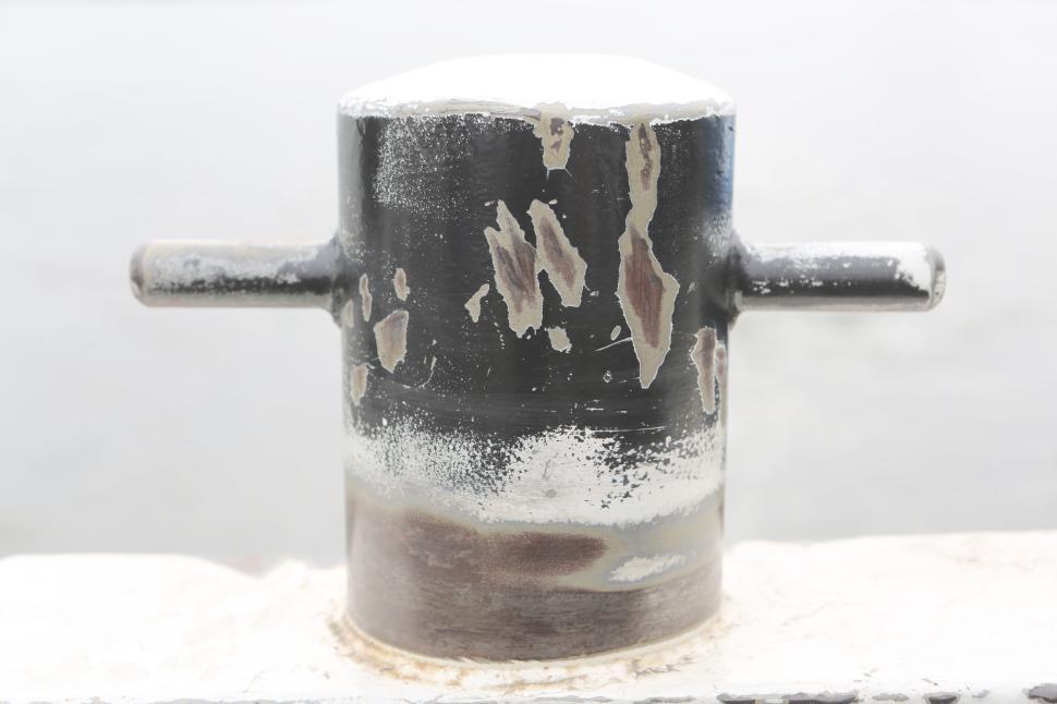 Free Image of Weathered bollard on a harbor pier against a misty gray background. 