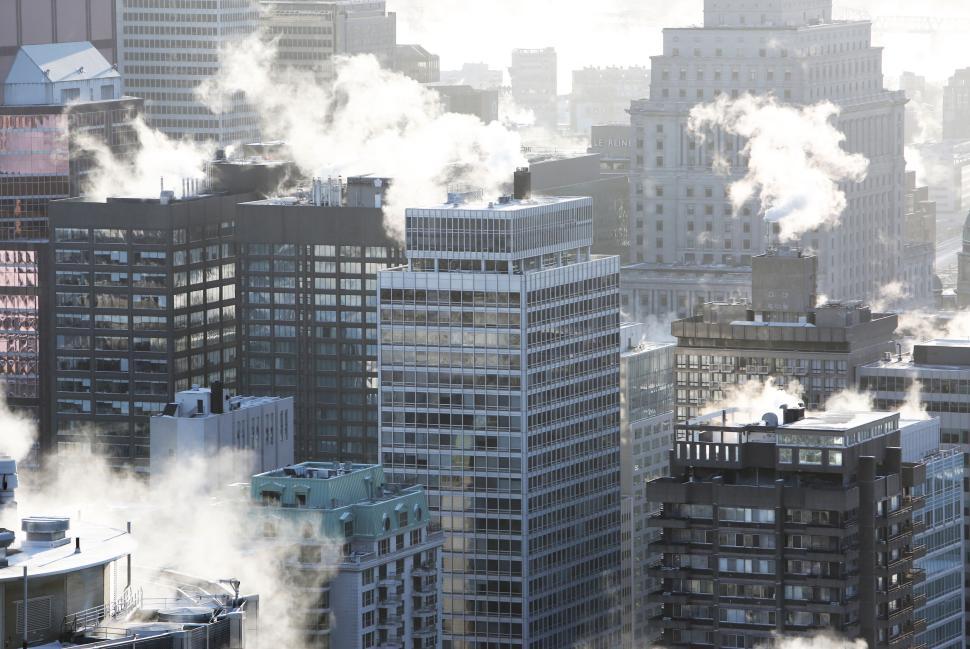 Free Image of City skyline with skyscrapers and steam rising in the early morning. 
