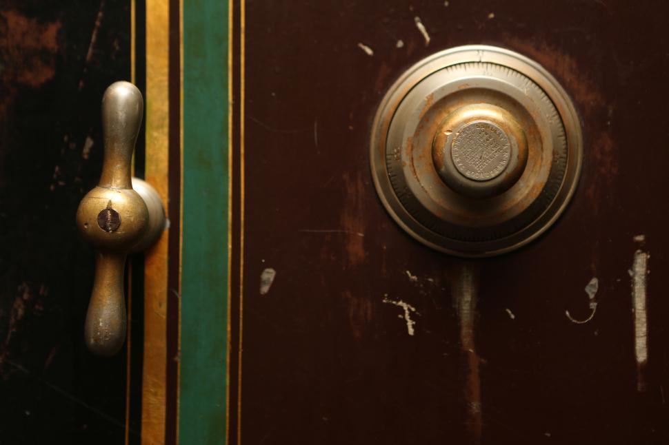 Free Image of A close-up of a vintage safe door with a combination lock and handle. 