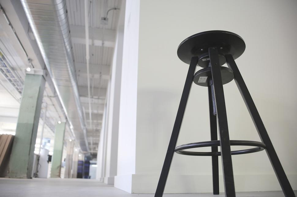 Free Image of Black metal high stool placed in a minimalist, industrial-style room. 