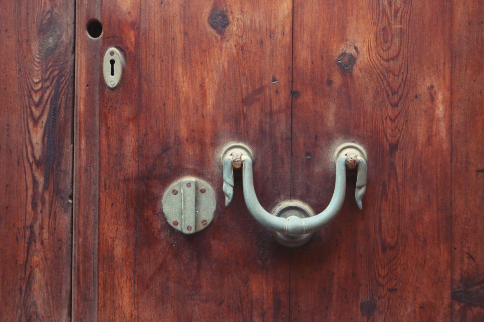 Free Image of Antique wooden door with decorative handle and keyhole on weathered wood. 