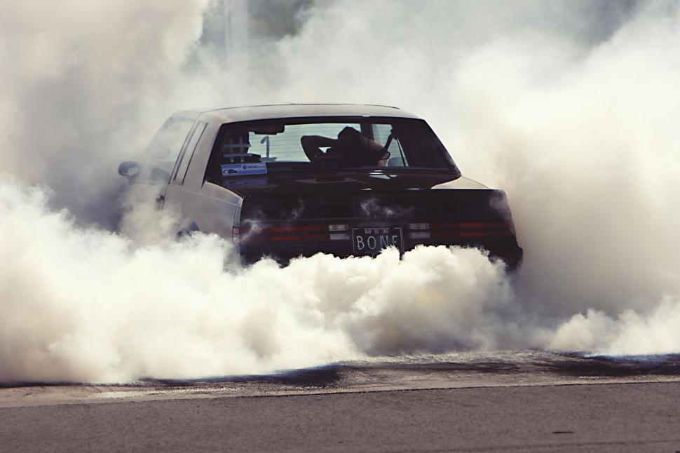 Free Image of Classic car doing burnout with lots of smoke and visible license plate 