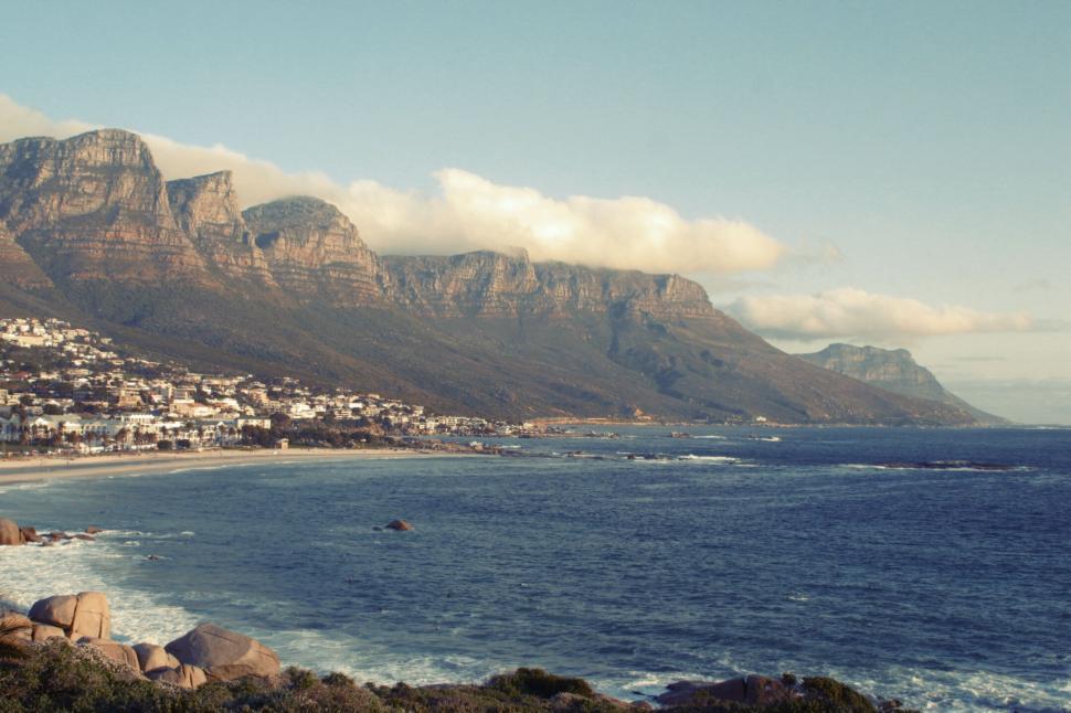 Free Image of Ocean coastlines with mountains in the background at sunset 