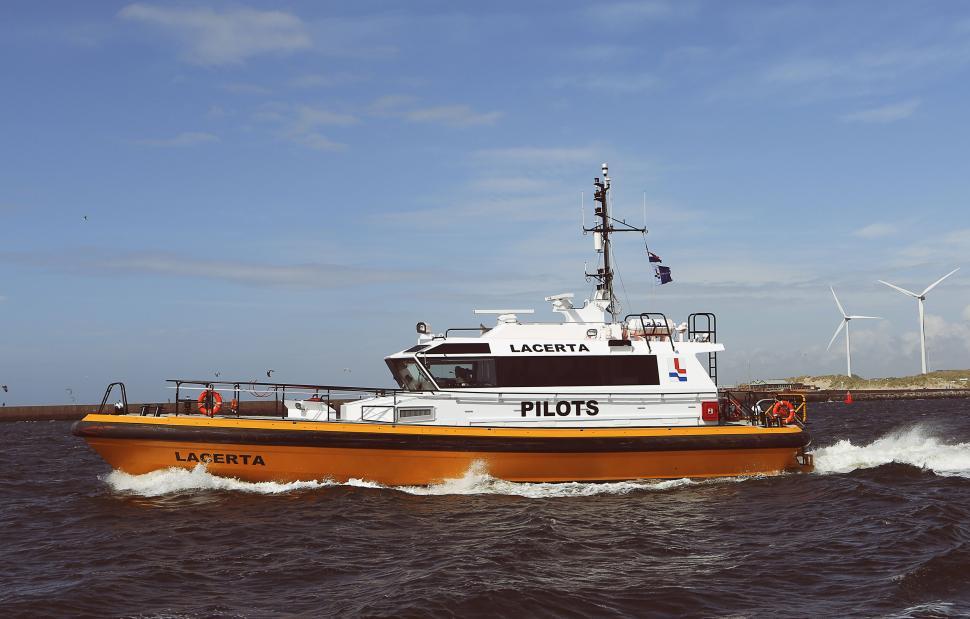Free Image of Lacerta pilot boat cruising on open water beside wind turbines 