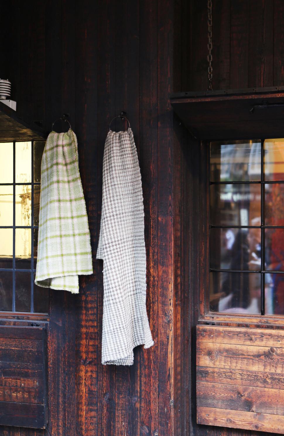 Free Image of Two checkered cloths hanging side by side on rustic wooden wall 