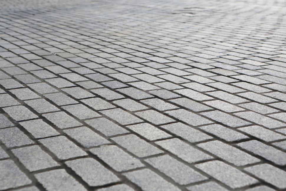 Free Image of Close-up view of a gray cobblestone pavement with uniform pattern. 