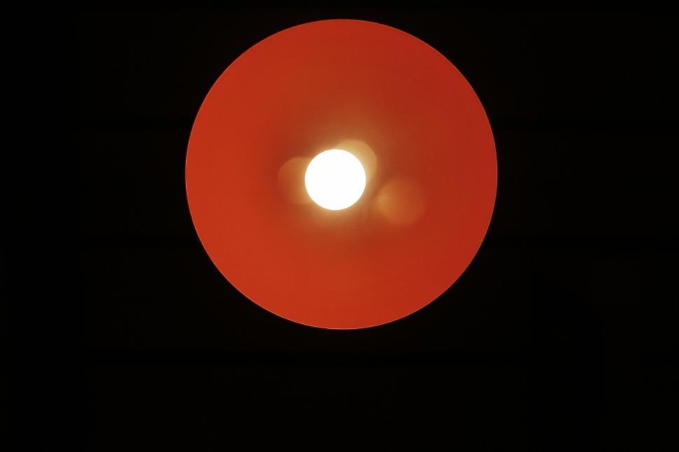 Free Image of Abstract view of a red circular ceiling light casting a glow 
