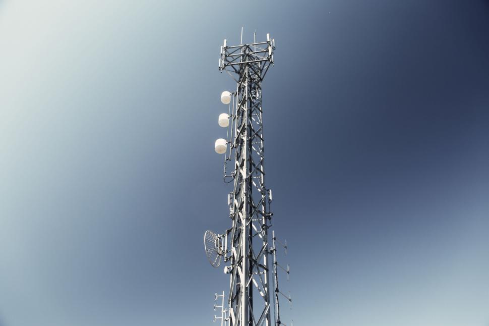 Free Image of Tall metal tower with multiple antennas against a clear blue sky 
