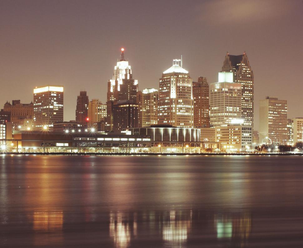 Free Image of Detroit city skyline at night with lit buildings reflecting in water 