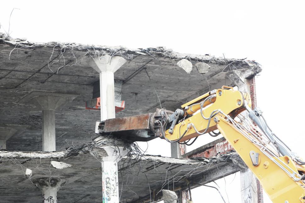 Free Image of Demolition of a concrete building with yellow excavator in action 