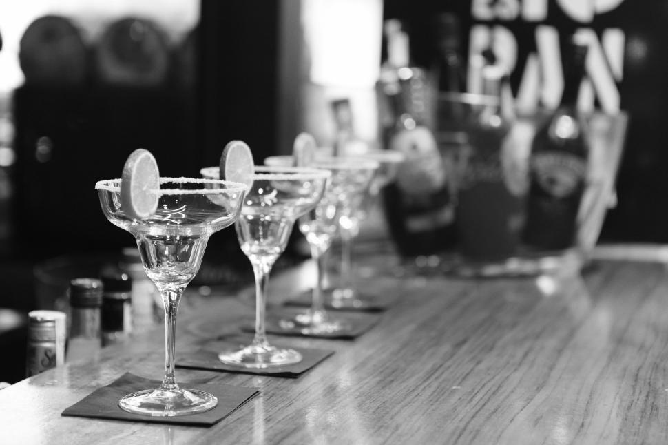 Free Image of Empty cocktail glasses lined up on a bar counter in a close-up shot. 