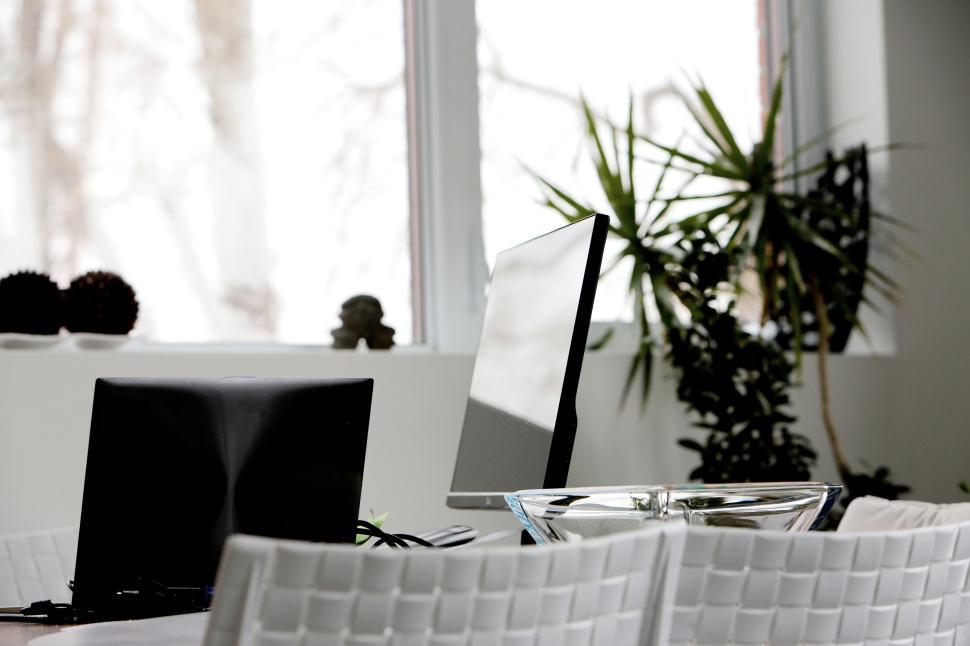 Free Image of Modern minimalistic office space with white chairs and computers. 
