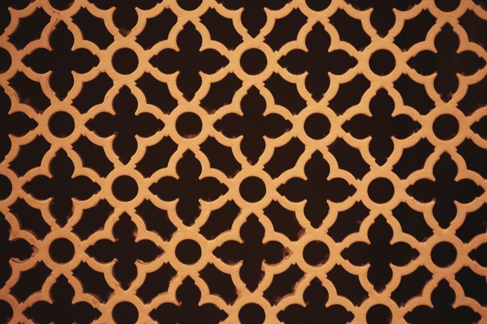 Free Image of Ornate decorative pattern with intricate design in warm lighting. 