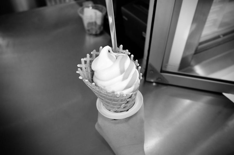 Free Image of Black and white image of a hand holding a soft serve ice cream cone. 