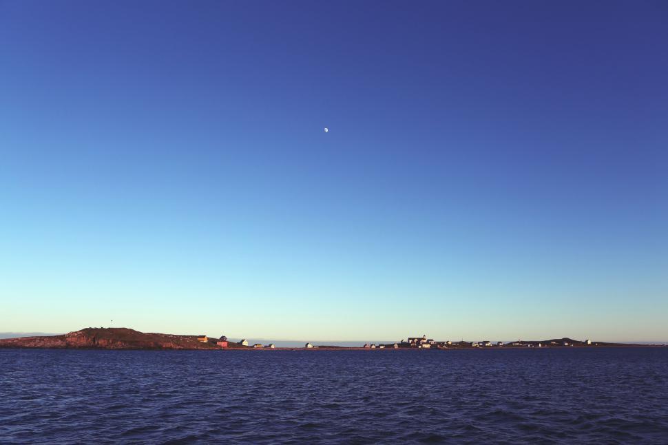 Free Image of Expansive ocean view with distant small island and clear blue sky. 