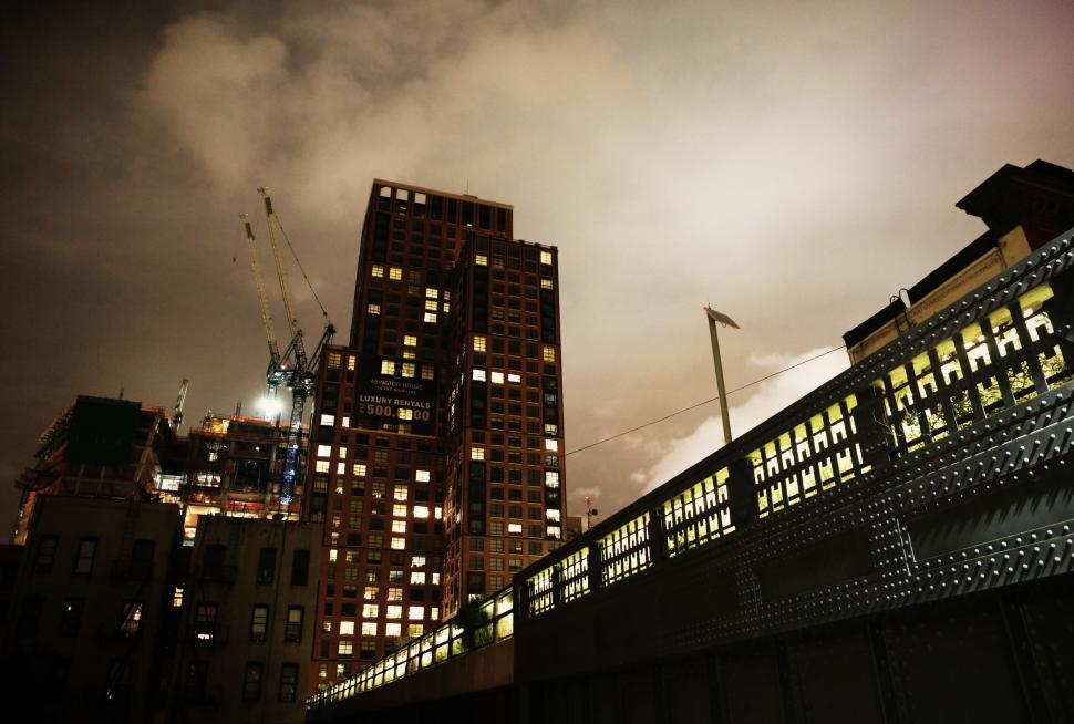 Free Image of Night cityscape with tall buildings and lights in the sky 