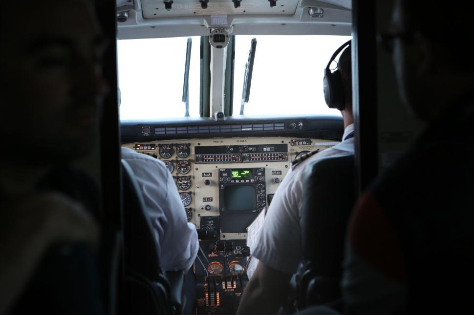 Free Image of Airplane cockpit with pilots in control on a daytime flight 