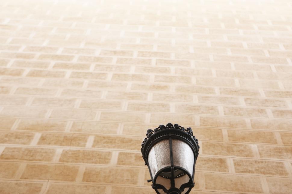 Free Image of Crown placed on a person s head with a blurred beige brick wall 