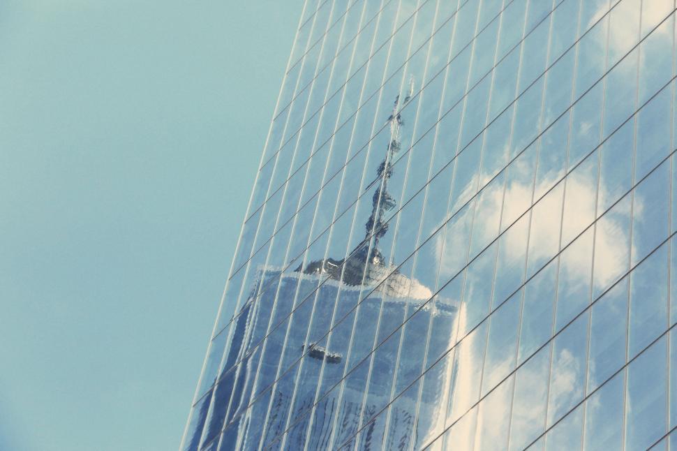 Free Image of Reflection of a skyscraper with antenna in mirrored glass building 